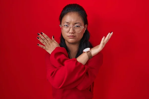Aziatisch Jong Vrouw Staande Rode Achtergrond Afwijzing Expressie Kruising Armen — Stockfoto