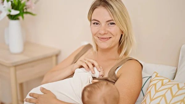 Mãe Filha Sentadas Cama Amamentando Bebê Quarto — Fotografia de Stock