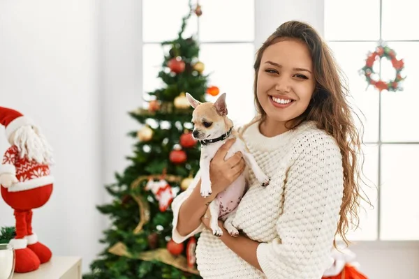Young Beautiful Hispanic Woman Hugging Chihuahua Standing Christmas Tree Home — ストック写真