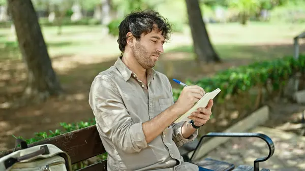Jovem Hispânico Escrevendo Caderno Sentado Banco Pensando Parque — Fotografia de Stock