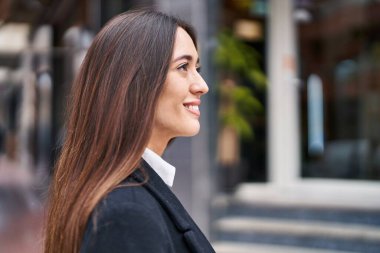 Young beautiful hispanic woman smiling confident looking to the side at street