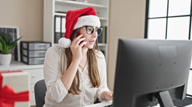 Genç, güzel, İspanyol bir iş adamı akıllı telefondan Noel 'i ofisinde kutluyor.