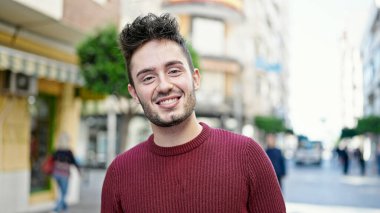 Sokakta kendinden emin gülümseyen İspanyol genç adam.