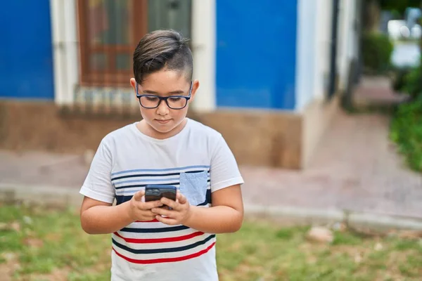 Adorable Niño Hispano Usando Smartphone Con Expresión Relajada Parque —  Fotos de Stock