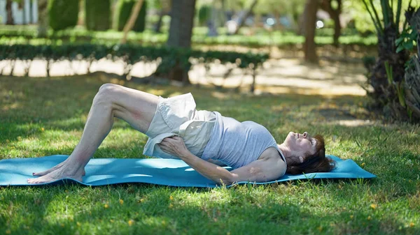 中年妇女在公园训练腹肌 — 图库照片
