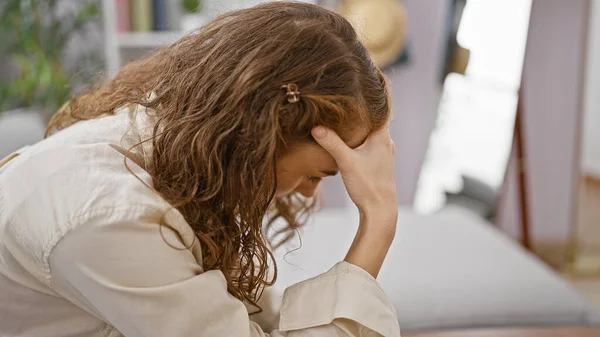 Mujer Joven Estresada Sentada Sola Sofá Casa Encarnando Tristeza Frustración —  Fotos de Stock