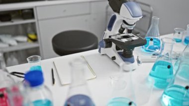 Laboratuvarın göbeğinde, orta yaşlı, sarışın bir bilim kadını güvenlik gözlükleri arkasında araştırma yoğunluğunu koruyor..