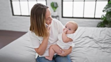 Sevgiyi hisset, kadın rahat bir şekilde yatakta oturuyor, güzel küçük kızına bakıyor, rahat yatak odalarında ciddi bir cep telefonu konuşması yapıyor.