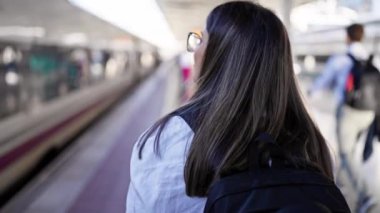 Tren istasyonunda yürüyen güzel İspanyol bir kadın.