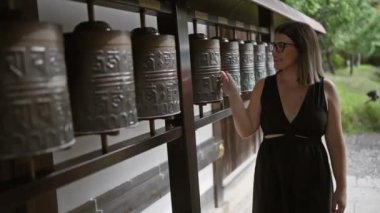 Dokunaklı maneviyat, güzel İspanyol kadın Kodaiji tapınağında dua tekerlekleri yuvarlıyor, Kyoto Budist kültürünü kucaklarken.