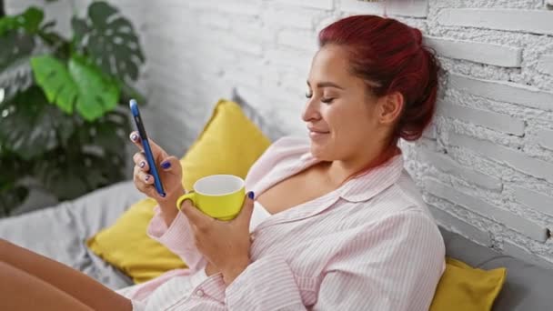 Junge Rothaarige Frau Trinkt Mit Smartphone Kaffee Schlafzimmer — Stockvideo
