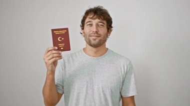 Yakışıklı sarışın yetişkin adam sevinçle ışıldıyor, Türk pasaportunu beyaz izole bir arka planda sallıyor, eğlence dolu bir tatile çıkıyor..