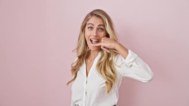 陽気な若いブロンドの女性は 単離されたピンクの壁の上に立って シャツを着て笑顔を浮かべます ポジティブなコミュニケーションについて — ストック動画