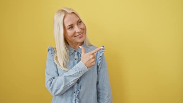 Бодрая Молодая Блондинка Стоящая Указывающая Вверх Джинсовой Рубашке Улыбающаяся Женщина — стоковое видео