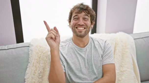 Veselý Mladý Muž Pohodlně Sedí Doma Pohovce Sebevědomě Ukazuje Usmívá — Stock video