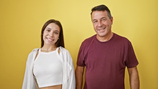 自信を持った父と娘は喜んで拳をぶつけて 晴れた黄色の孤立した背景で笑顔で絆を祝います — ストック動画