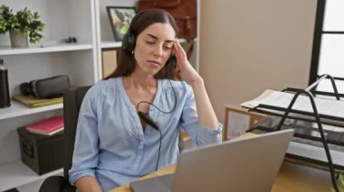 Genç ve güzel İspanyol bir kadın, ofiste acı çekiyor. Kulaklık takarken strese bağlı migren yüzünden elleriyle başını tutuyor. Üzgün ifadesi hastalığının acısını ortaya çıkarıyor..