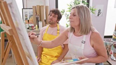 Yaratıcılığın kalbinde, iki kendine güvenen sanatçı, erkek ve kadın, yeteneklerini serbest bırakarak, rahat bir sanat stüdyosu atmosferinde birlikte hareket ediyorlar.