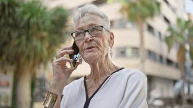 Kendine güveni tam, gri saçlı, güneşli bir günün tadını çıkaran, şehrin sokaklarında gülen ve mutlu bir şekilde akıllı telefonuyla konuşan son sınıf öğrencisi..