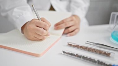 Kendini işine adamış İspanyol bilim kadını. Laboratuar defterine notlar karalıyor. Kapalı alanda tutku ve biyomedikal araştırmalar yapıyor.