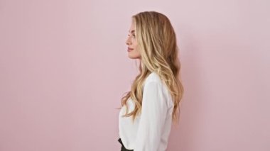 Heyecanlı genç sarışın kadın, pembe giymiş, mutlu bir reklam sunuyor! Avuç içi açıkken, izole arkaplanda kopya alanı gösteriliyor. Sıradan bir gömlek giyiyor, jesti bulaşıcı..