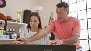 Tutkulu İspanyol erkek ve kadın müzisyenler hoş bir müzik stüdyosunda melodik bir piyano dersine daldılar.