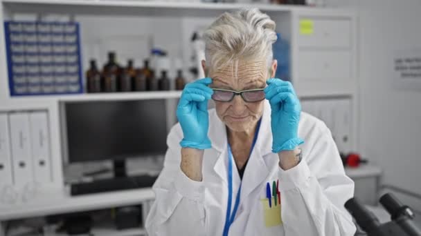 グレー髪の女性科学者は眼鏡をかけ 重要な医学研究室の仕事に魅了されました — ストック動画