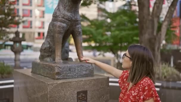 在富丽堂皇的东京大街上 戴眼镜的惊慌失措的女人摸着标志性的花栗子雕像 沉浸在日本的文化和传统之中 — 图库视频影像