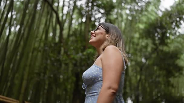안경을 아름다운 히스패닉 그녀는 기쁨과 놀라움으로 교토의 무성한 대나무 사이에 — 비디오