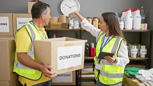 남성과 봉사자의 따뜻한 센터에서 기부를 패키지를 확인하기 패드를 사용하여 — 비디오