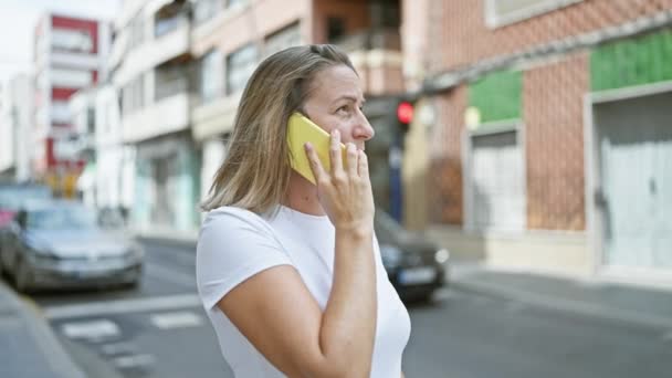 Νεαρή Ξανθιά Γυναίκα Που Μιλάει Στο Τηλέφωνο Στο Δρόμο — Αρχείο Βίντεο