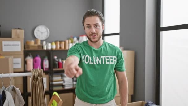 Joven Hombre Hispano Voluntario Señalando Cámara Sonriendo Centro Caridad — Vídeo de stock