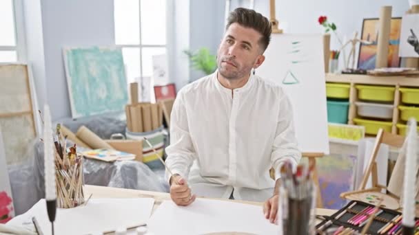 Svém Uměleckém Studiu Mladý Pohledný Hispánec Sebejistě Uvězněný Myšlenkách Kreslící — Stock video