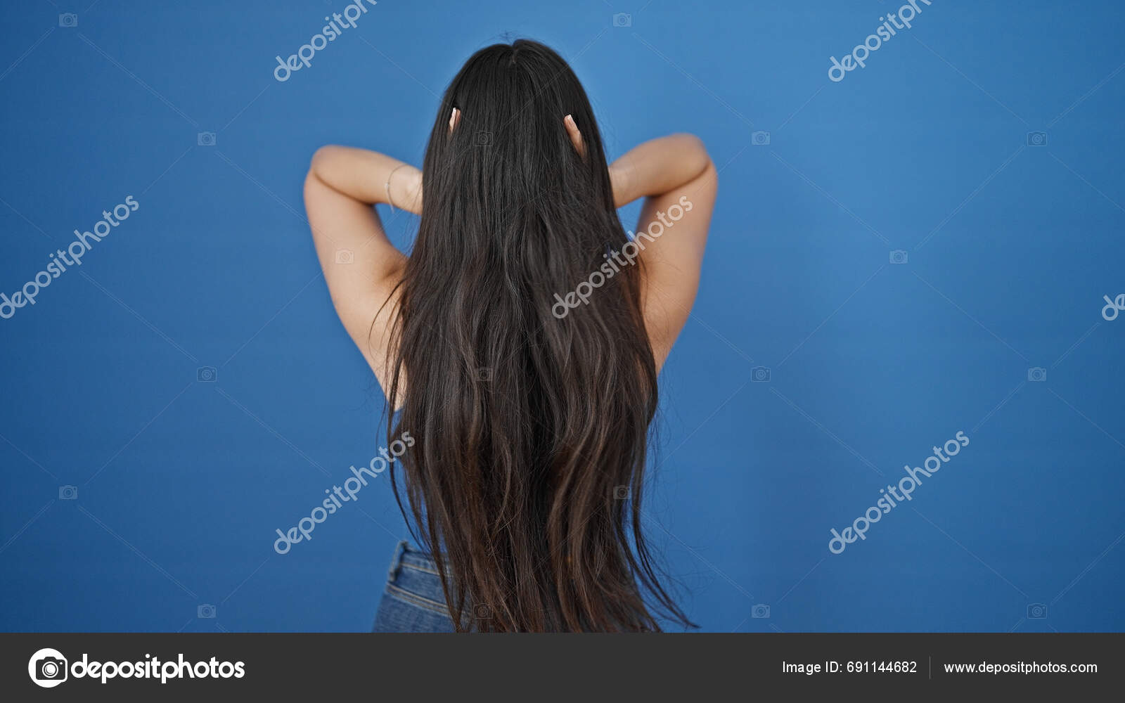 Young Beautiful Hispanic Woman Touching Her Hair Backwards Isolated