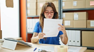 Genç ve güzel bir İspanyol kadın. İş kadını. Ofiste gülümseyen belgeler okuyor.