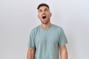 Beyaz arka planda sakallı İspanyol bir adam öfkeli ve öfkeli bağırıyor öfkeyle bağırıyor. öfke ve agresif konsept. 