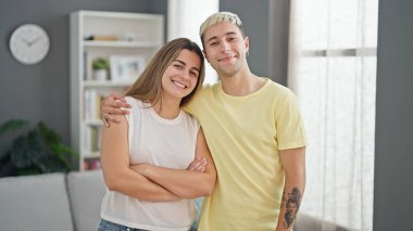 Güzel bir çift gülümsüyor. Evde birbirlerine sarılıyorlar.