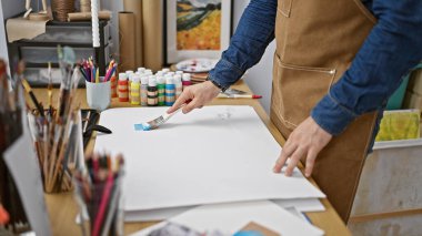 Tutkulu genç İspanyol sanatçı sanat stüdyosundaki fırçasıyla coşkulu bir şekilde çizim yapıyor, kendini sanatına vermiş.