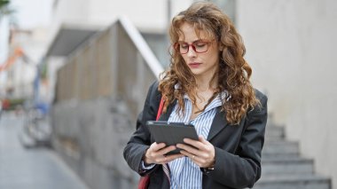 Sokakta dokunmatik ped kullanan genç bir iş kadını.