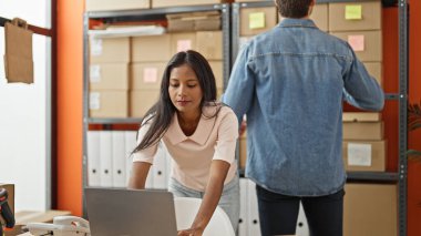 Ofiste çalışan iki işçi ve kadın dizüstü bilgisayar kullanıyor.