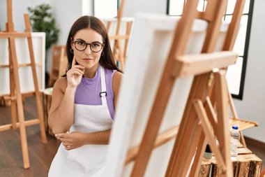 Resim stüdyosunda resim çizen genç, güzel İspanyol kadın sanatçı.