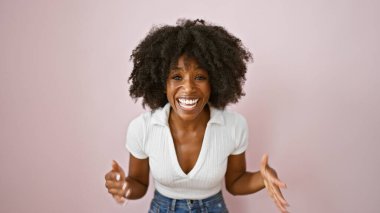 Afro-Amerikalı kadın pembe arka planda çok gülüyor.
