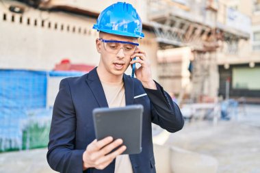 Genç İspanyol mimar, dokunmatik ped kullanıyor ve caddede akıllı telefondan konuşuyor.