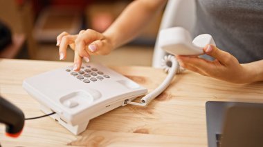 Genç sarışın kadın dış ticaret işçisi. Ofiste telefon numarasına basıyor.