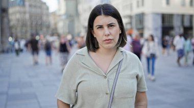 Viyana sokaklarında ciddi bir ifadeyle duran genç, güzel İspanyol kadın.