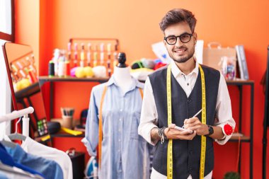 Genç İspanyol terzi atölyedeki defterde kendinden emin bir şekilde yazıyor.