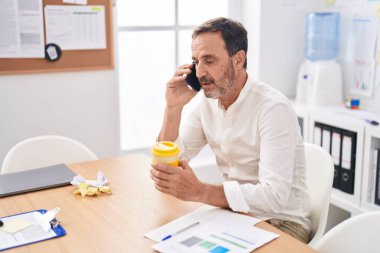 Middle age man business worker talking on smartphone working at office