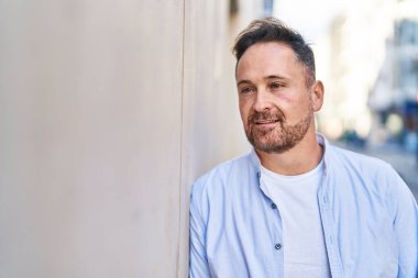 Young caucasian man smiling confident looking to the side at street