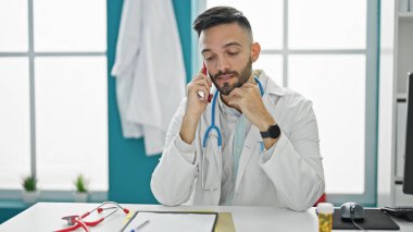 Genç İspanyol doktor, klinikte çalışan akıllı telefondan konuşuyor.