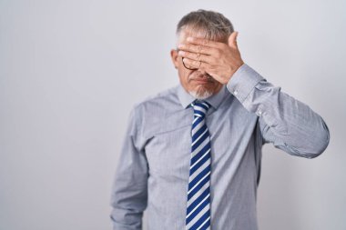 İspanyol iş adamı, gri saçlı, gözlüklü, eli gözlüklü, ciddi ve üzgün görünüyor. Görme, saklama ve reddetme konsepti 